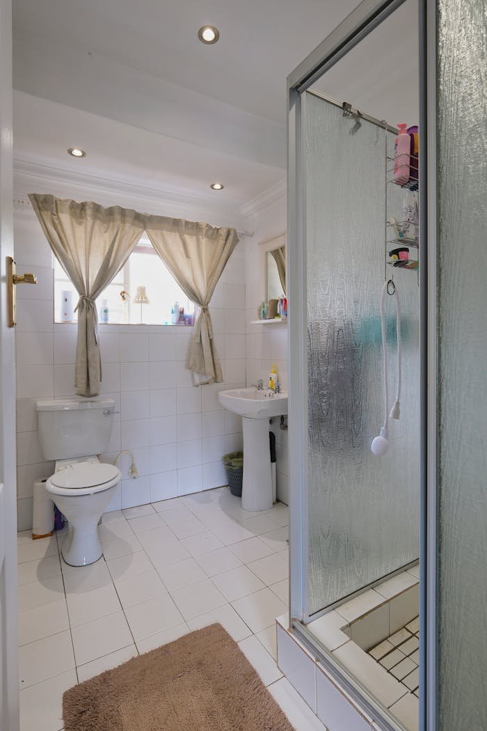 Bright and contemporary bathroom interior in Pretoria, showcasing a shower, toilet, and sink.