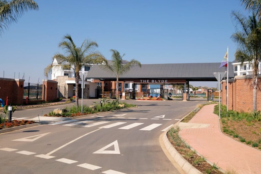 Entrance to The Blyde residential complex showcasing modern architecture and palm trees.